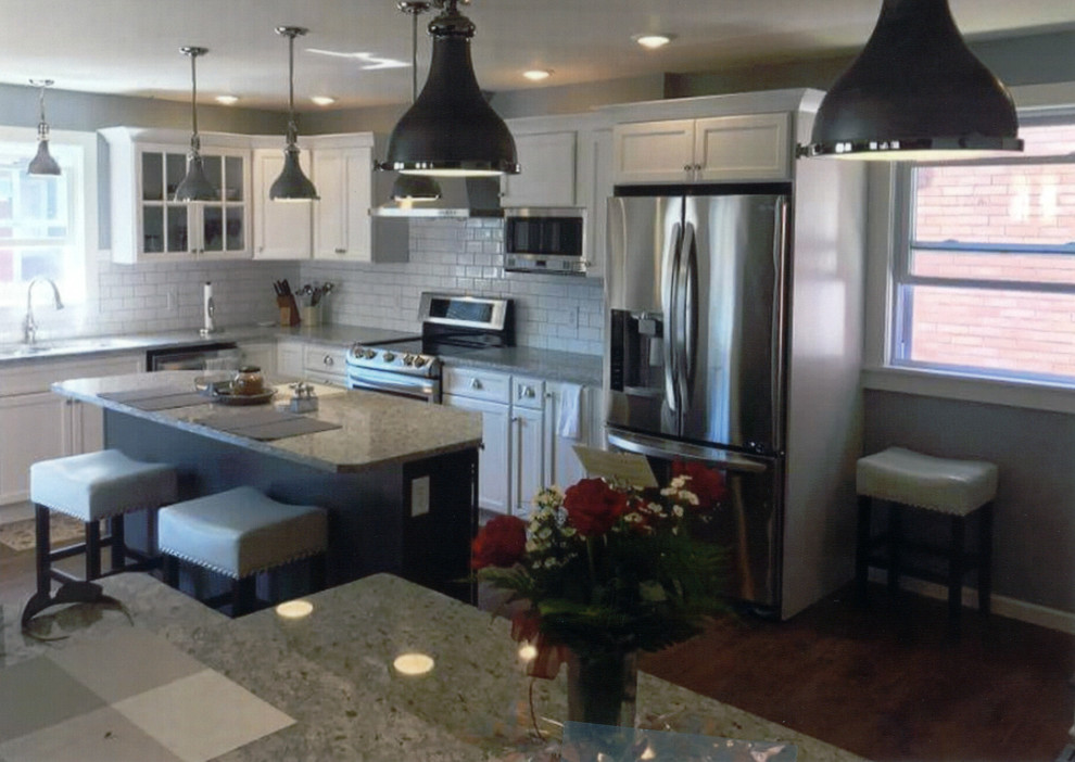 Inspiration for a large transitional l-shaped medium tone wood floor and brown floor eat-in kitchen remodel with shaker cabinets, white cabinets, granite countertops, white backsplash, subway tile backsplash, stainless steel appliances, an island, beige countertops and an undermount sink