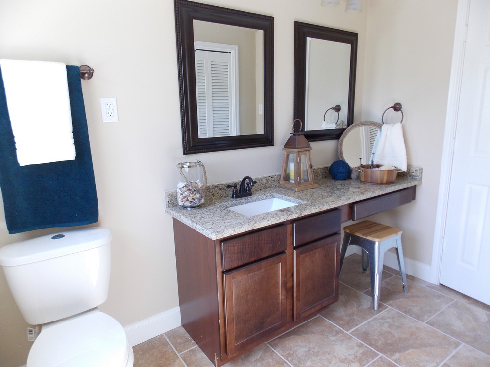 Mid-sized traditional kids bathroom in Austin with an undermount sink, shaker cabinets, medium wood cabinets, granite benchtops, an alcove tub, a shower/bathtub combo, a two-piece toilet, multi-coloured tile, ceramic tile, beige walls and ceramic floors.