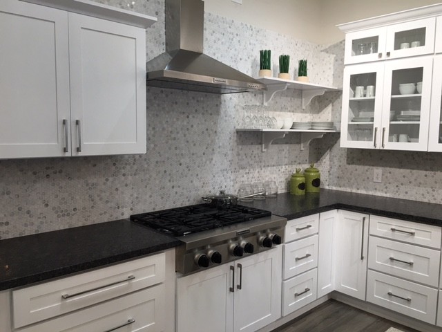 Enclosed kitchen - mid-sized transitional l-shaped dark wood floor and gray floor enclosed kitchen idea in Orange County with white cabinets, gray backsplash, mosaic tile backsplash, stainless steel appliances, shaker cabinets, granite countertops and an island