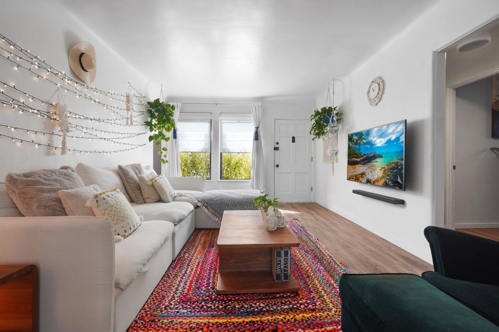 Idee per un soggiorno mediterraneo di medie dimensioni e aperto con pareti bianche, pavimento in legno massello medio, TV a parete e pavimento multicolore