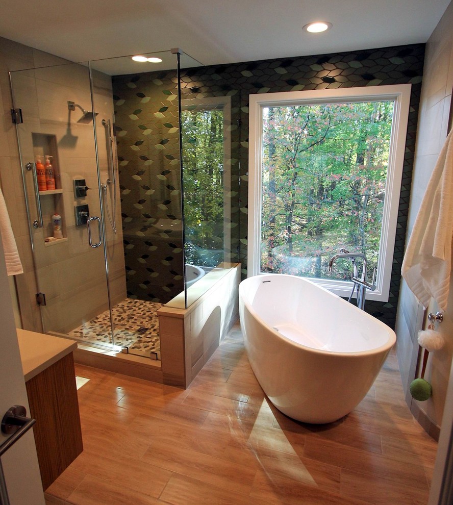 Photo of a mid-sized asian master bathroom in DC Metro with light wood cabinets, a japanese tub, a corner shower, a one-piece toilet, green tile, porcelain tile, green walls, porcelain floors, a vessel sink, engineered quartz benchtops, brown floor and a hinged shower door.