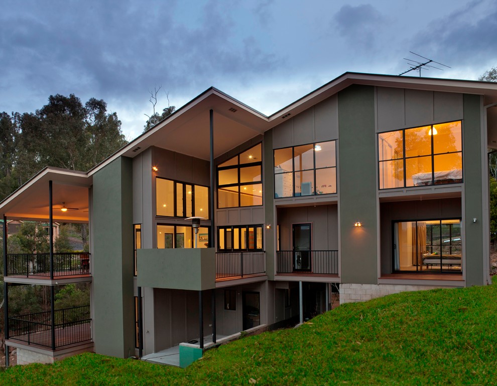 Photo of an expansive beach style three-storey grey exterior in Brisbane with wood siding and a gable roof.