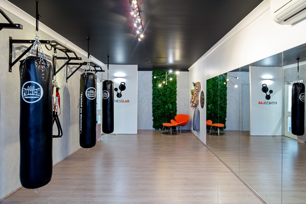 Mid-sized contemporary home weight room in Sydney with grey walls, light hardwood floors and beige floor.