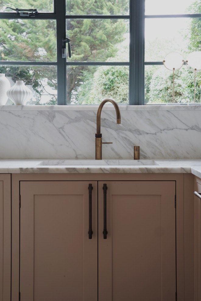 Medium sized traditional l-shaped kitchen in London with a submerged sink, shaker cabinets, pink cabinets, quartz worktops, white splashback, an island and white worktops.