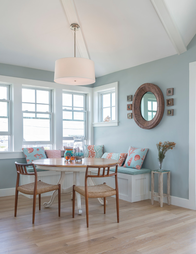 This is an example of a beach style dining room in Providence with blue walls and light hardwood floors.