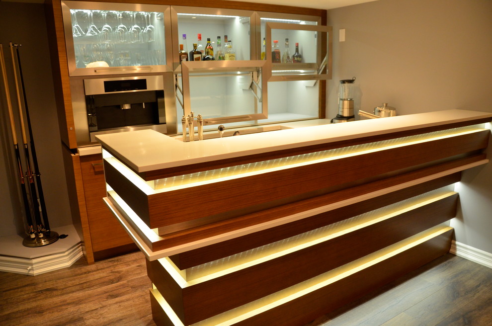 This is an example of a mid-sized modern l-shaped seated home bar in Toronto with an undermount sink, shaker cabinets, white cabinets, quartzite benchtops and travertine floors.