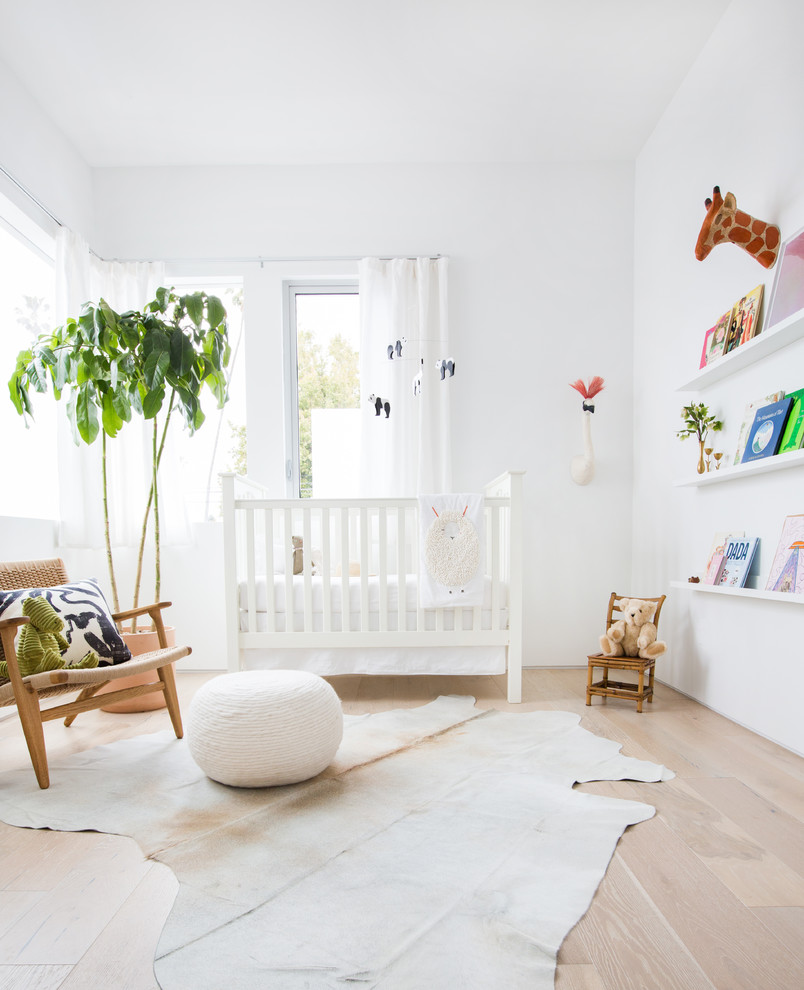 Aménagement d'une chambre de bébé fille contemporaine de taille moyenne avec un mur blanc et parquet clair.
