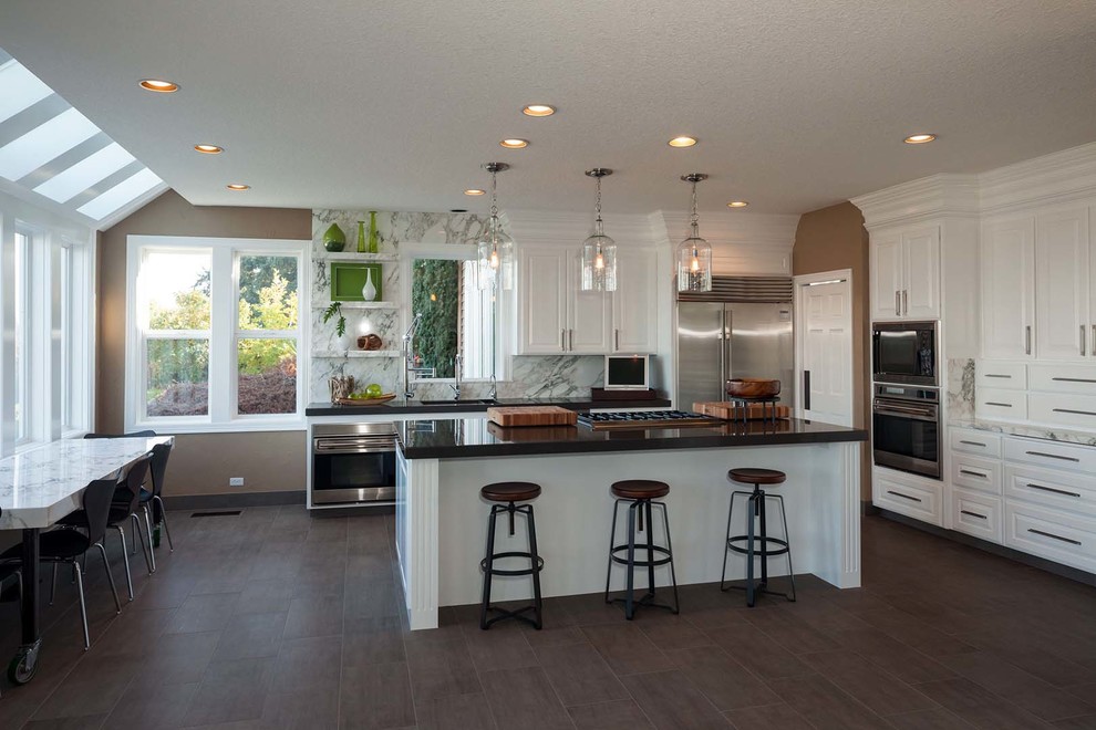 Kitchen - large transitional dark wood floor kitchen idea with a drop-in sink, raised-panel cabinets, white cabinets, quartzite countertops, stone slab backsplash, stainless steel appliances and an island