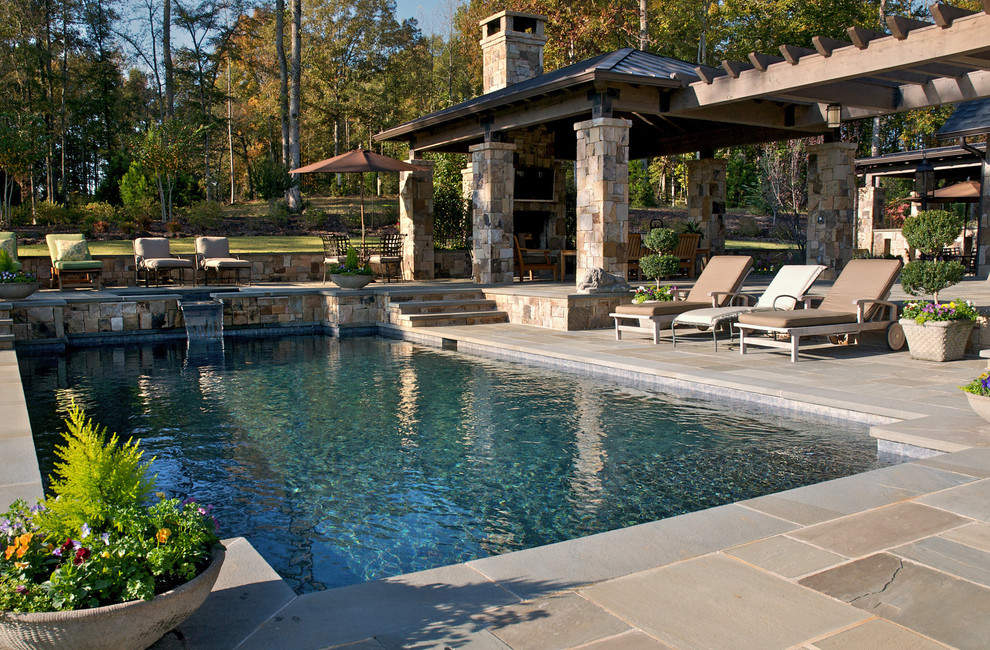 Design ideas for a mid-sized country backyard rectangular pool in Atlanta with a water feature and natural stone pavers.