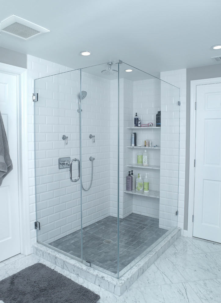 Photo of a large transitional master wet room bathroom in New York with a freestanding tub, grey walls, marble floors, marble benchtops, shaker cabinets, grey cabinets, a one-piece toilet, white tile, subway tile, an undermount sink, multi-coloured floor, a hinged shower door and multi-coloured benchtops.