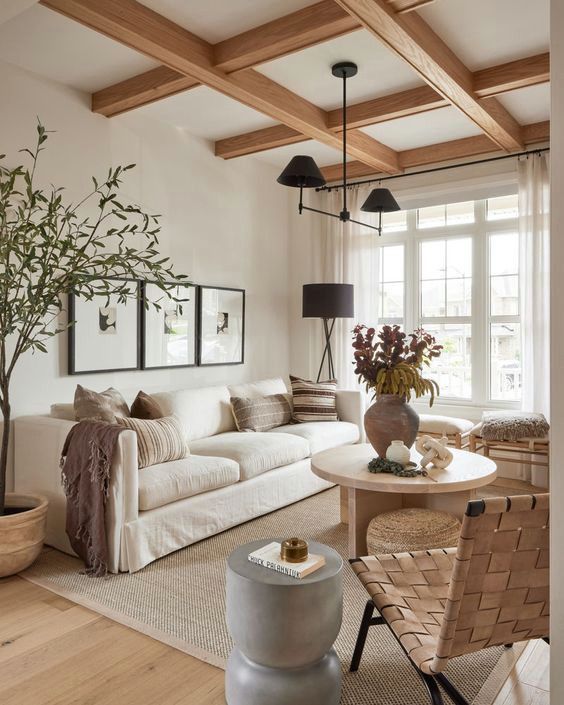 Imagen de salón abierto y blanco y madera marinero pequeño con paredes beige, suelo de madera clara, televisor retractable, suelo marrón y vigas vistas