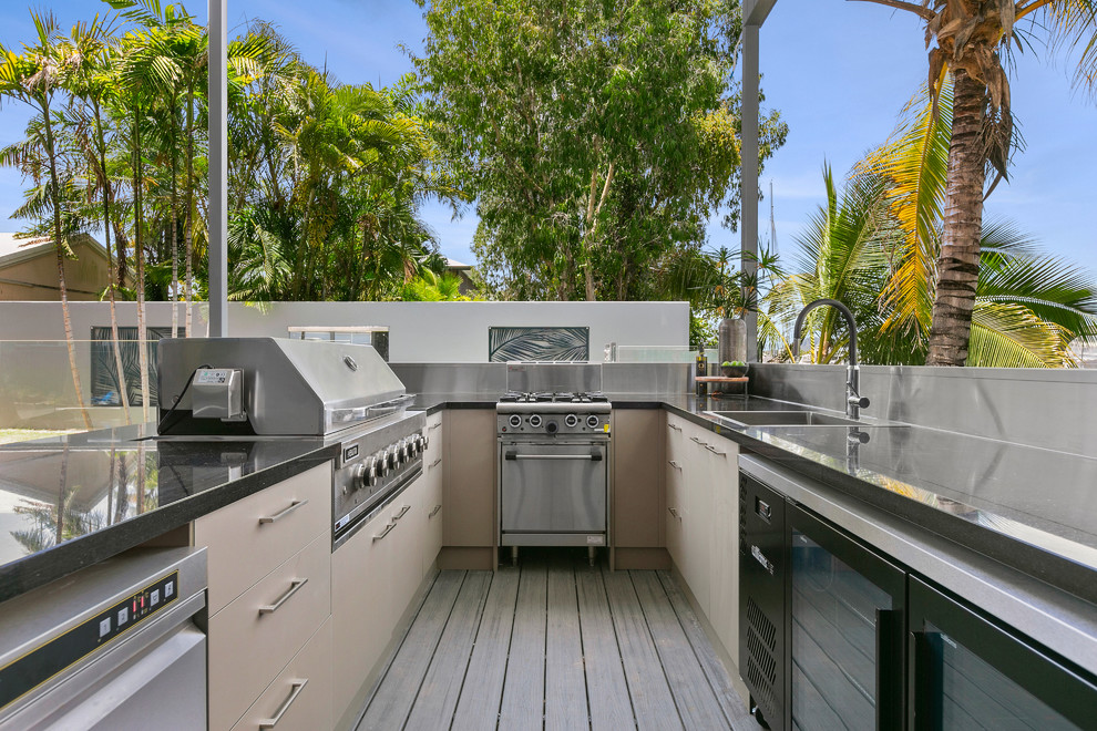 Small tropical rooftop and rooftop deck in Cairns with an outdoor kitchen and no cover.