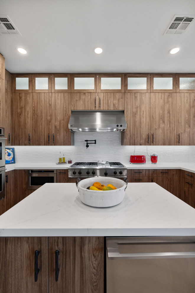 Enclosed kitchen - rustic l-shaped slate floor and beige floor enclosed kitchen idea with a single-bowl sink, flat-panel cabinets, medium tone wood cabinets, quartzite countertops, white backsplash, glass sheet backsplash, stainless steel appliances, a peninsula and white countertops
