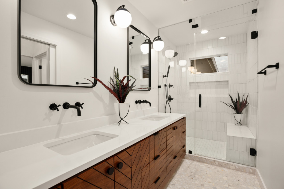 Contemporary bathroom in Austin with flat-panel cabinets, medium wood cabinets, an alcove shower, white tile, white walls, an undermount sink, grey floor, a hinged shower door, white benchtops, a niche, a shower seat, a double vanity and a floating vanity.