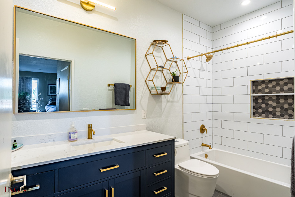 Inspiration för mellanstora moderna vitt en-suite badrum, med släta luckor, blå skåp, ett badkar i en alkov, en dusch i en alkov, en toalettstol med hel cisternkåpa, vit kakel, keramikplattor, vita väggar, klinkergolv i keramik, ett nedsänkt handfat, bänkskiva i kvarts, dusch med duschdraperi och grått golv