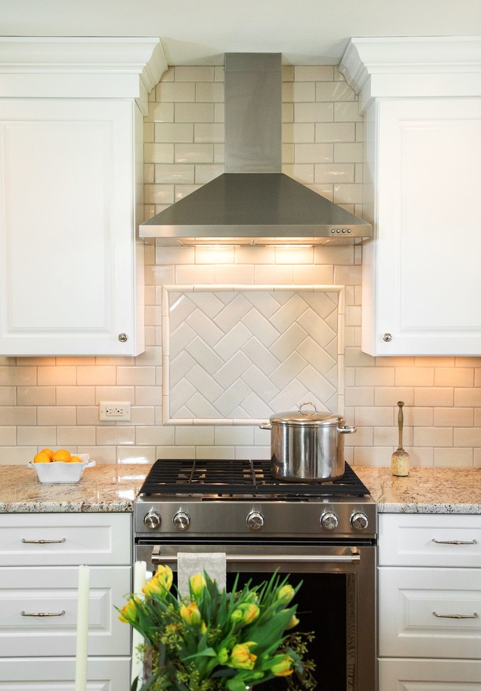 This is an example of a small traditional l-shaped eat-in kitchen in Nashville with an undermount sink, raised-panel cabinets, white cabinets, granite benchtops, white splashback, ceramic splashback, stainless steel appliances, light hardwood floors and no island.