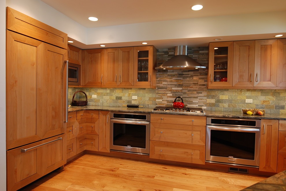 Inspiration for a mid-sized transitional u-shaped eat-in kitchen remodel in Chicago with shaker cabinets, light wood cabinets, granite countertops, multicolored backsplash, porcelain backsplash and paneled appliances