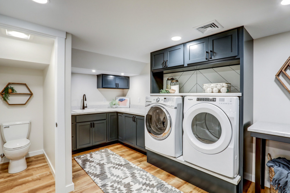 Design ideas for a large traditional l-shaped separated utility room in Other with a built-in sink, recessed-panel cabinets, blue cabinets, laminate countertops, white walls, vinyl flooring, a side by side washer and dryer, brown floors, grey worktops and tongue and groove walls.