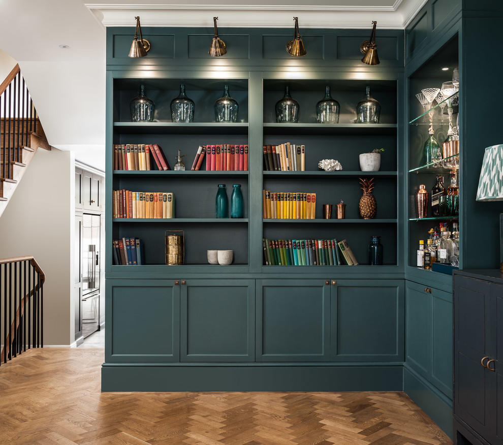 This is an example of a mid-sized traditional open concept living room in London with a home bar, green walls and medium hardwood floors.