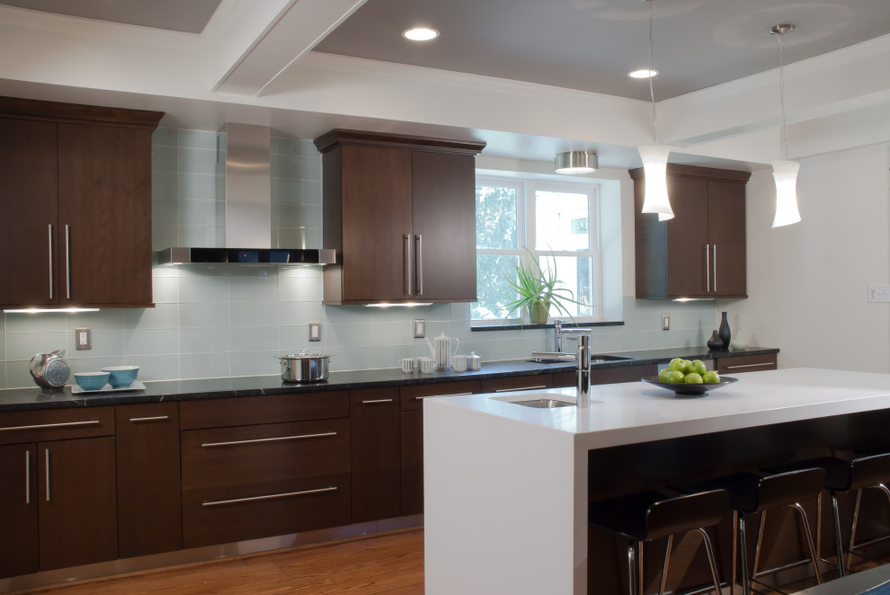 Mid-sized contemporary galley separate kitchen in St Louis with an undermount sink, flat-panel cabinets, dark wood cabinets, quartz benchtops, grey splashback, glass tile splashback, stainless steel appliances, medium hardwood floors, with island, brown floor, white benchtop and coffered.