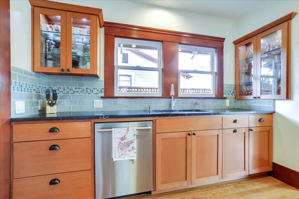 Photo of a large arts and crafts separate kitchen in San Francisco with an undermount sink, shaker cabinets, light wood cabinets, blue splashback, ceramic splashback, stainless steel appliances, light hardwood floors, with island and yellow floor.