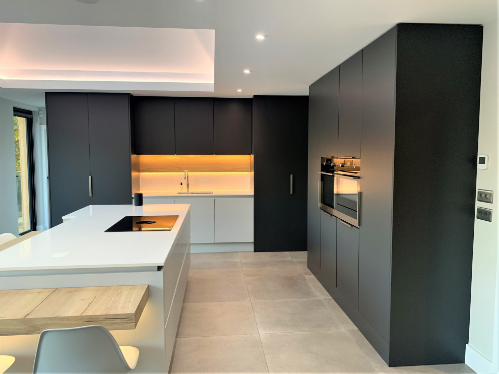 Inspiration for a large contemporary l-shaped eat-in kitchen in Other with a single-bowl sink, flat-panel cabinets, light wood cabinets, quartzite benchtops, black appliances, vinyl floors, with island, grey floor and white benchtop.