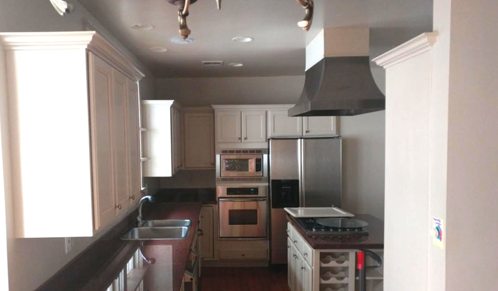 Enclosed kitchen - mid-sized transitional l-shaped dark wood floor and brown floor enclosed kitchen idea in Charlotte with a double-bowl sink, shaker cabinets, white cabinets, granite countertops, stainless steel appliances and an island