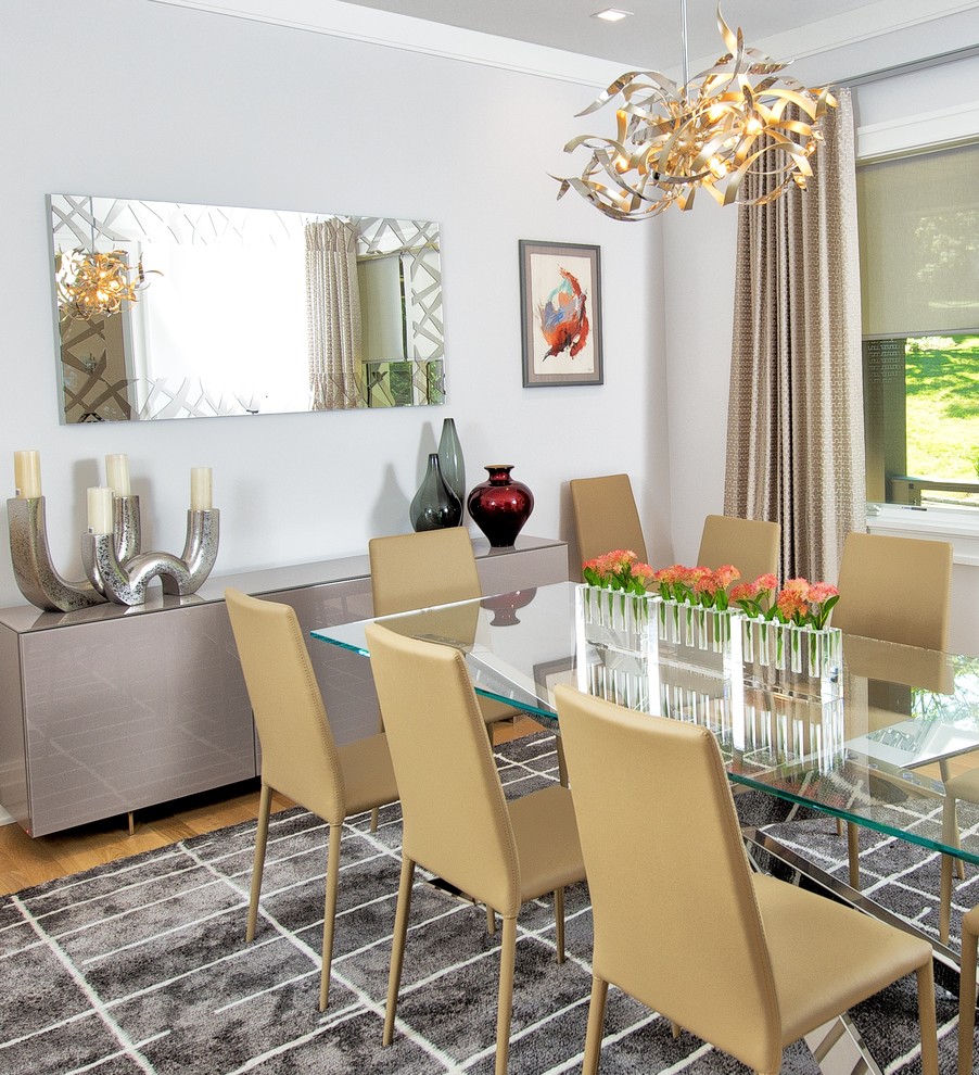 Photo of a mid-sized modern separate dining room in New York with white walls, light hardwood floors, no fireplace and brown floor.