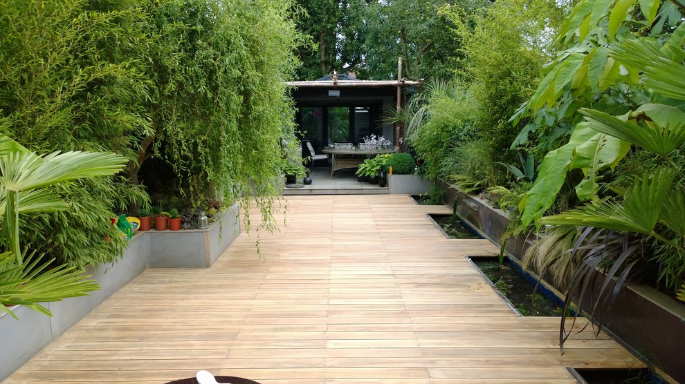 Design ideas for a mid-sized tropical full sun garden in Berkshire with decking and a container garden.
