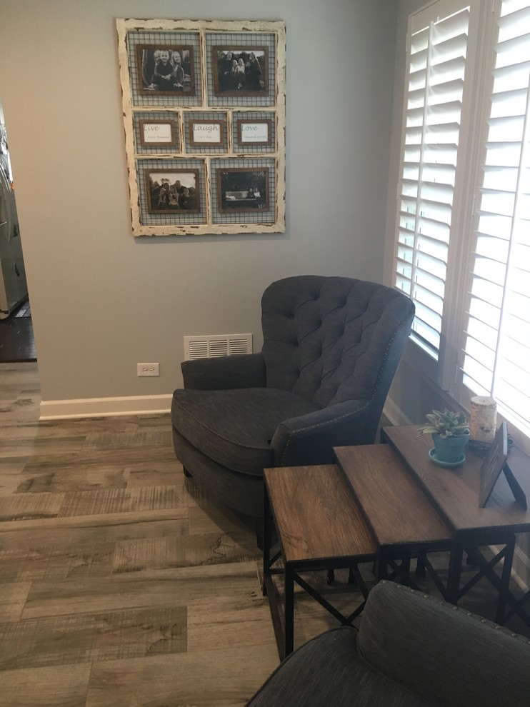 Large transitional gray floor home design photo in Chicago with gray walls, a standard fireplace and a wood fireplace surround