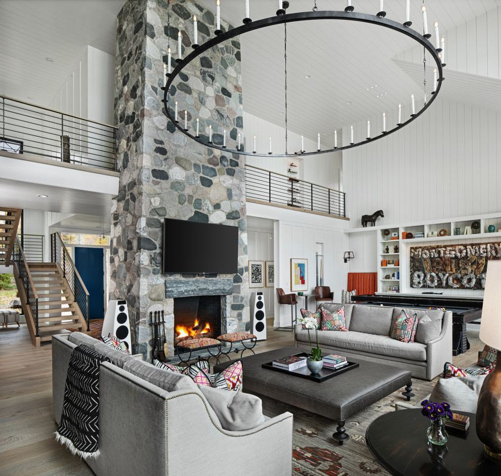Example of a transitional medium tone wood floor living room design in Detroit with white walls, a ribbon fireplace, a stone fireplace and a wall-mounted tv