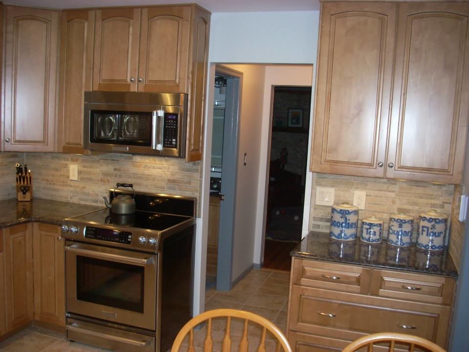 Kitchen - small galley ceramic tile kitchen idea in DC Metro with brown cabinets, granite countertops, ceramic backsplash and stainless steel appliances
