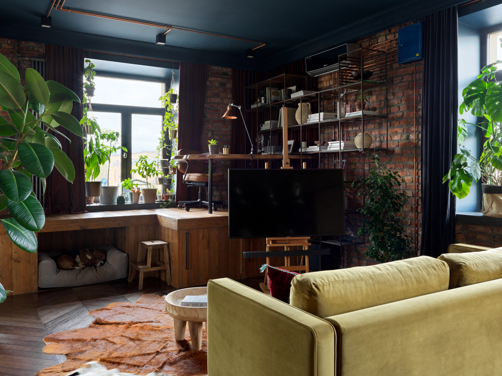This is an example of a mid-sized industrial formal open concept living room in Saint Petersburg with red walls, dark hardwood floors, a freestanding tv, brown floor and brick walls.