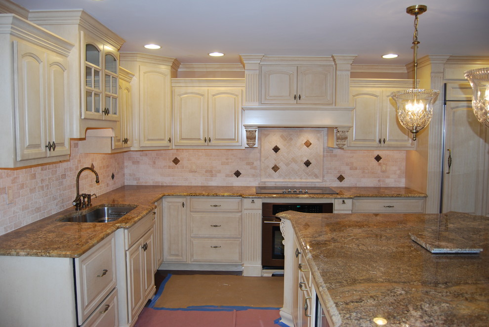 Medium tone wood floor kitchen photo with a double-bowl sink, medium tone wood cabinets, granite countertops, beige backsplash and stainless steel appliances
