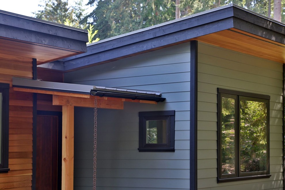 Inspiration for a mid-sized modern one-storey exterior in Seattle with mixed siding and a flat roof.