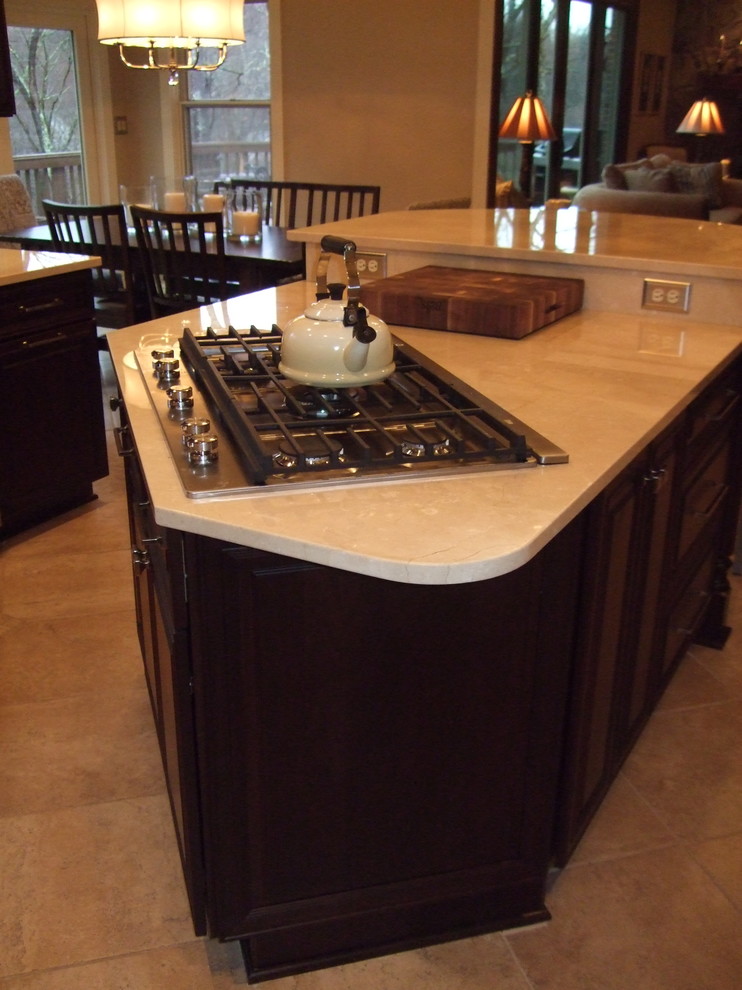 Inspiration for a large transitional kitchen remodel with a single-bowl sink, raised-panel cabinets, dark wood cabinets, marble countertops, stainless steel appliances and an island