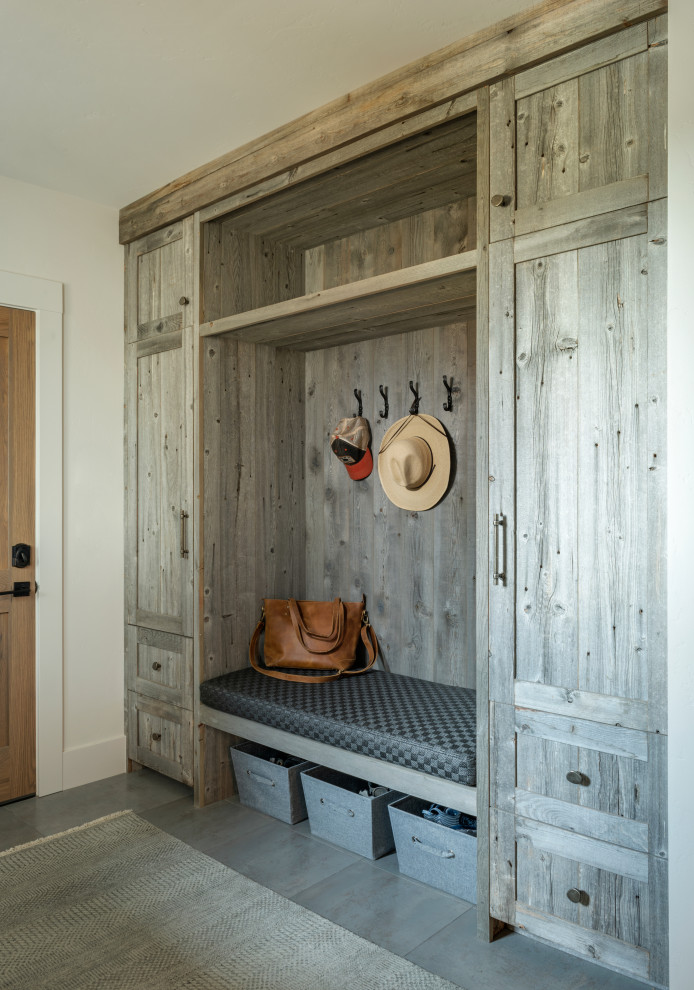 Photo of a country mudroom in Other with porcelain floors.