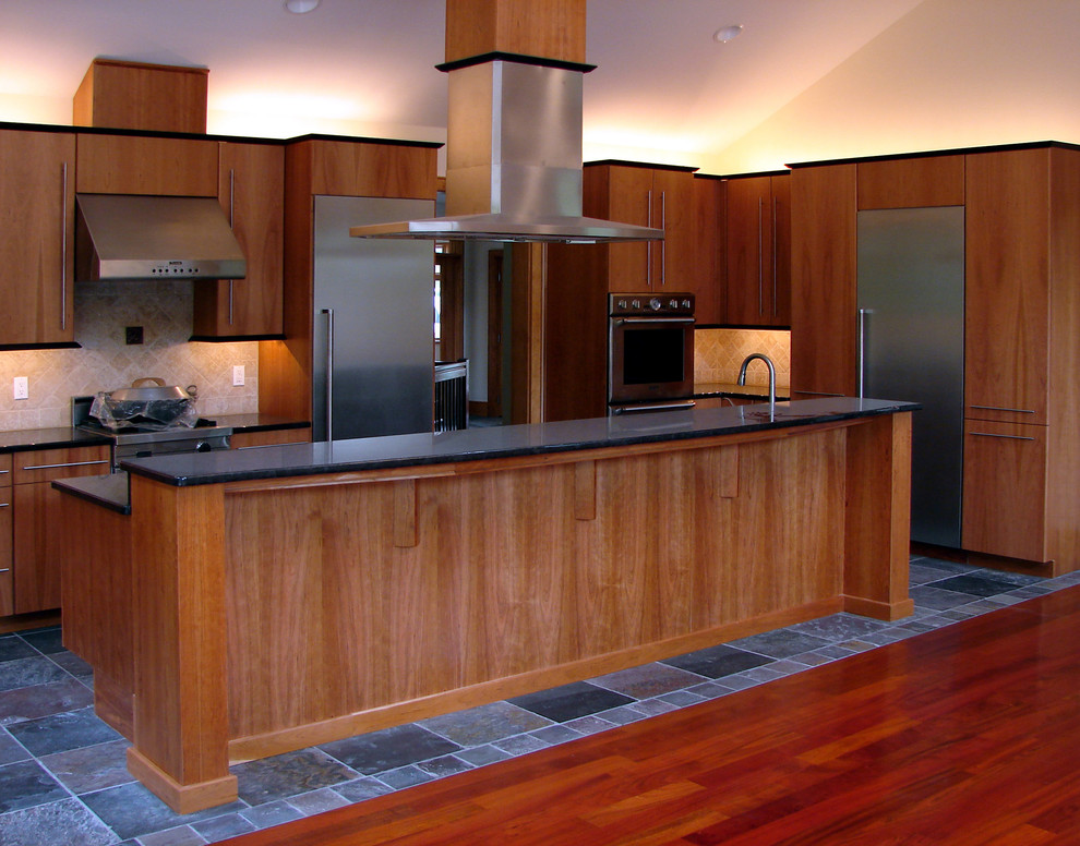 Photo of a large contemporary u-shaped eat-in kitchen in Philadelphia with an undermount sink, flat-panel cabinets, medium wood cabinets, stainless steel appliances, with island, beige splashback, slate floors and grey floor.