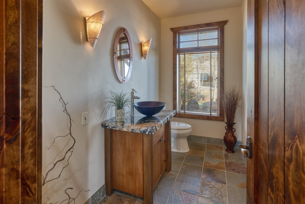 Exempel på ett mellanstort lantligt flerfärgad flerfärgat badrum med dusch, med släta luckor, bruna skåp, en toalettstol med hel cisternkåpa, beige kakel, beige väggar, klinkergolv i terrakotta, ett fristående handfat, granitbänkskiva och flerfärgat golv