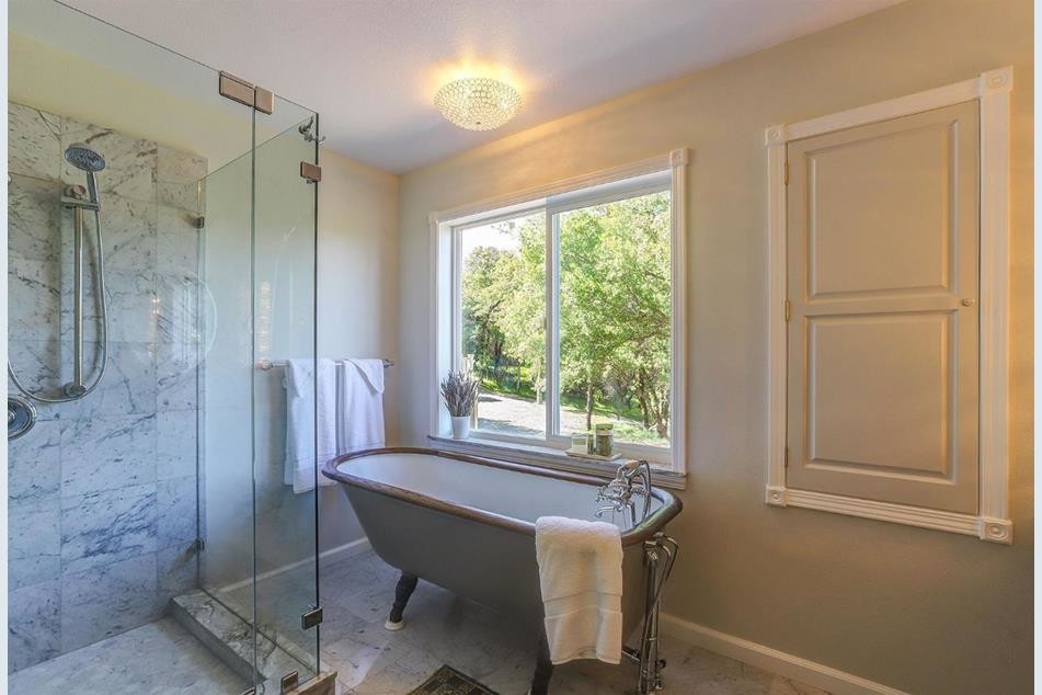 Photo of a mid-sized transitional master bathroom in Sacramento with raised-panel cabinets, grey cabinets, a claw-foot tub, a corner shower, marble, grey walls, marble floors, an undermount sink, quartzite benchtops, white floor, a hinged shower door and grey benchtops.