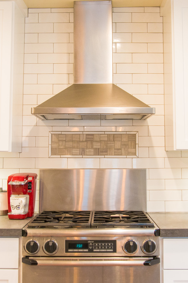 Transitional porcelain tile home design photo in Sacramento with a farmhouse sink, shaker cabinets, white cabinets, white backsplash, subway tile backsplash, stainless steel appliances and an island