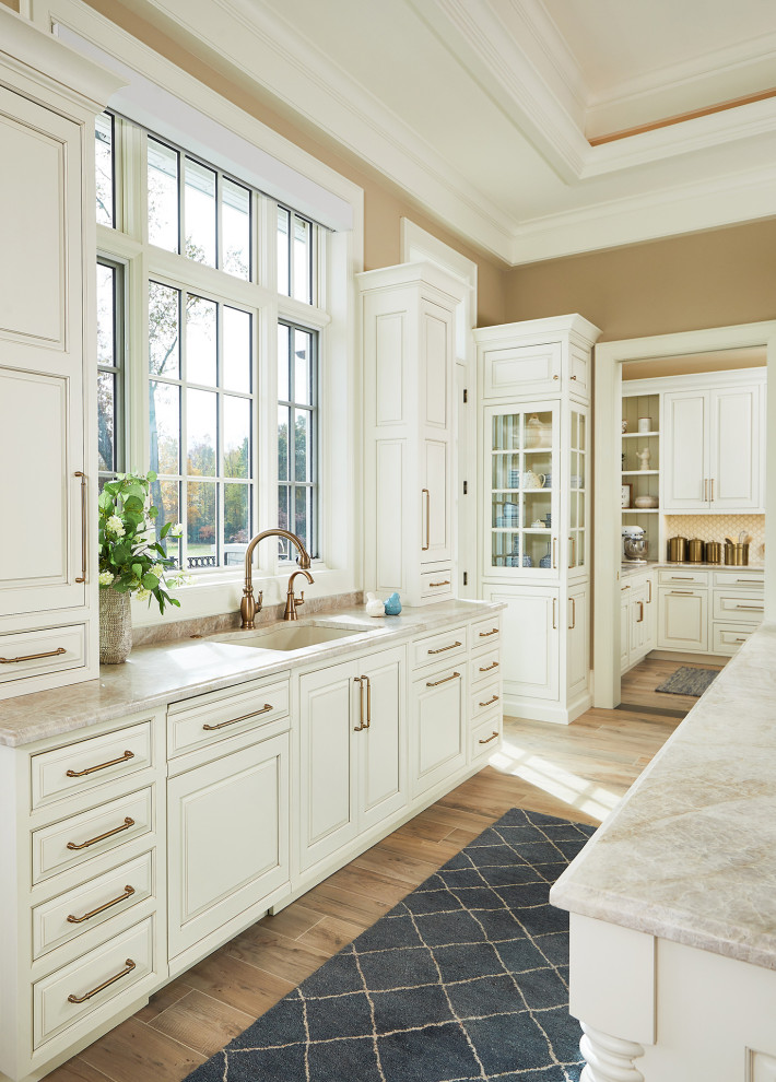 This is an example of a galley open plan kitchen in Grand Rapids with a submerged sink, beaded cabinets, white cabinets, engineered stone countertops, beige splashback, porcelain splashback, light hardwood flooring, multiple islands, beige floors, beige worktops and a drop ceiling.