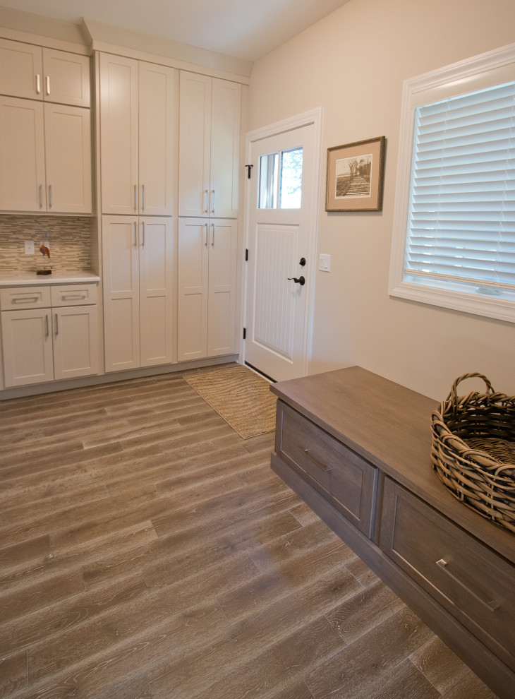 Inspiration for a traditional mudroom in Other with beige walls, medium hardwood floors and brown floor.