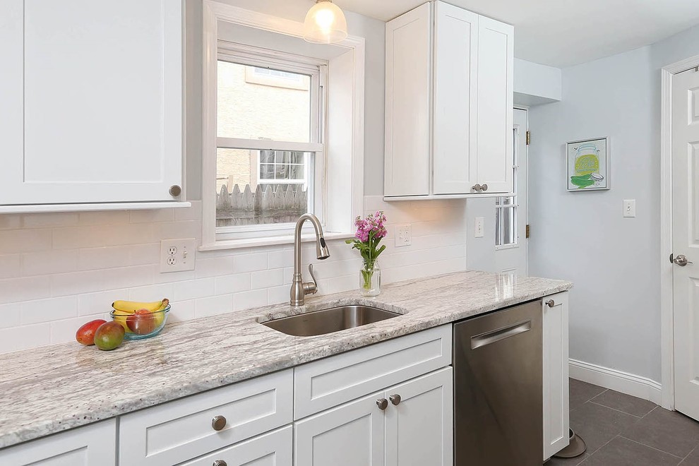 This is an example of a small contemporary galley separate kitchen in Philadelphia with an undermount sink, white cabinets, marble benchtops, white splashback, subway tile splashback, stainless steel appliances, porcelain floors, no island and grey floor.