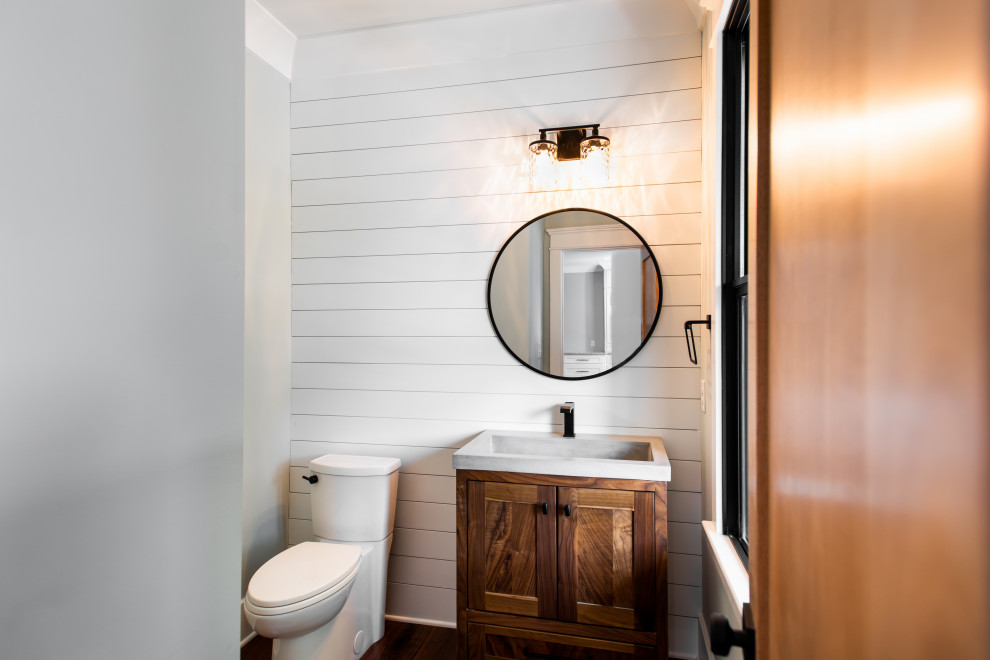 Idéer för mellanstora vintage grått toaletter, med skåp i mellenmörkt trä, en toalettstol med separat cisternkåpa, grå väggar, mellanmörkt trägolv, ett integrerad handfat och bänkskiva i betong