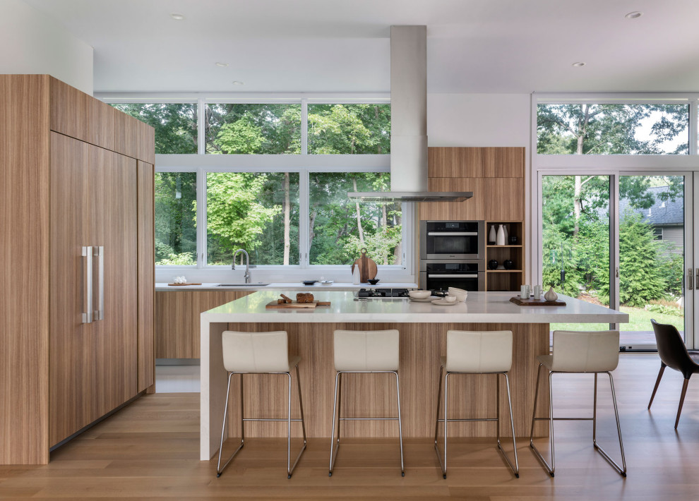 Foto di una cucina moderna con lavello sottopiano, ante lisce, ante in legno scuro, paraspruzzi a finestra, elettrodomestici da incasso, parquet chiaro, pavimento beige e top bianco