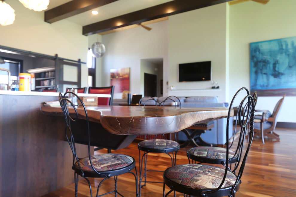 Example of a large transitional galley medium tone wood floor and brown floor home design design with an undermount sink, recessed-panel cabinets, medium tone wood cabinets, quartzite countertops, red backsplash, glass tile backsplash, stainless steel appliances and an island