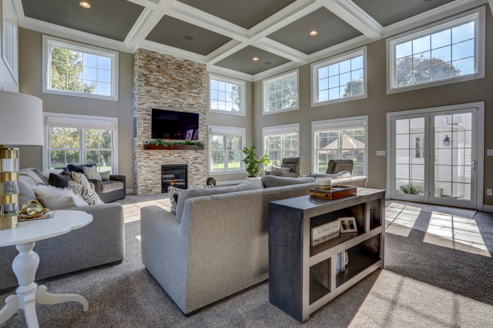 Design ideas for an expansive open concept family room with grey walls, carpet, a standard fireplace, a stone fireplace surround, a wall-mounted tv, grey floor and coffered.