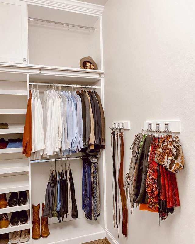 Contemporary gender-neutral walk-in wardrobe in Los Angeles with shaker cabinets, white cabinets, laminate floors and brown floor.