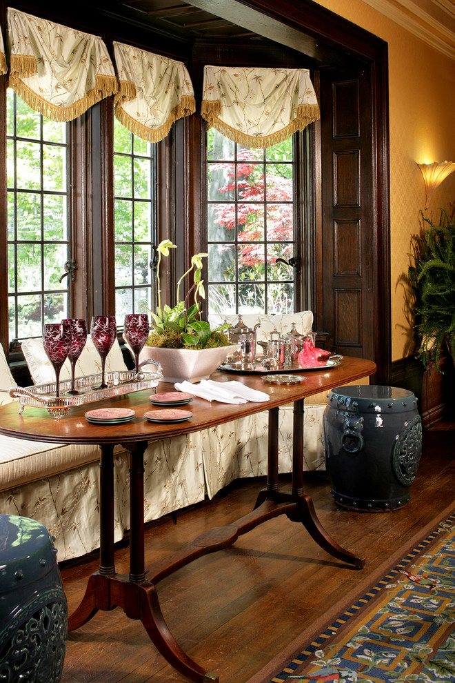 This is an example of a large eclectic separate dining room in New York with yellow walls and dark hardwood floors.